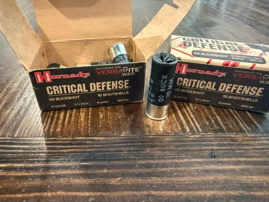 Hornady Critical Defense 12-gauge 00 buckshot shotshells with open box on wooden table.