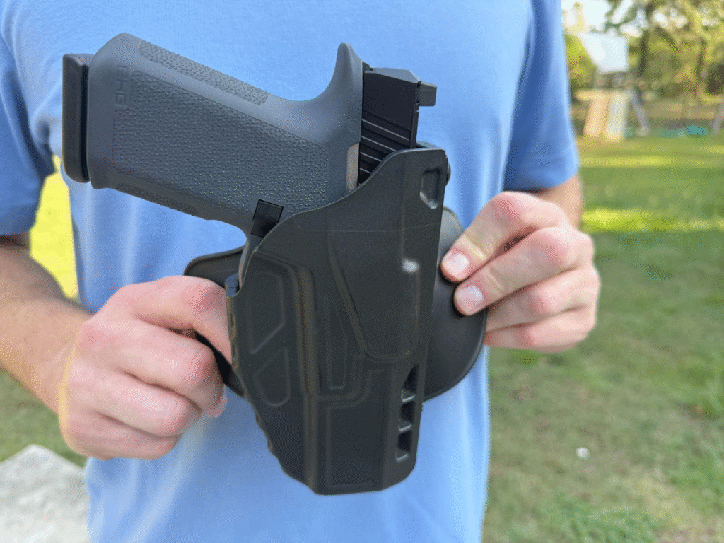 Ruger RXM compact 9mm pistol in Safariland ALS Model 7378 OWB holster held outdoors.