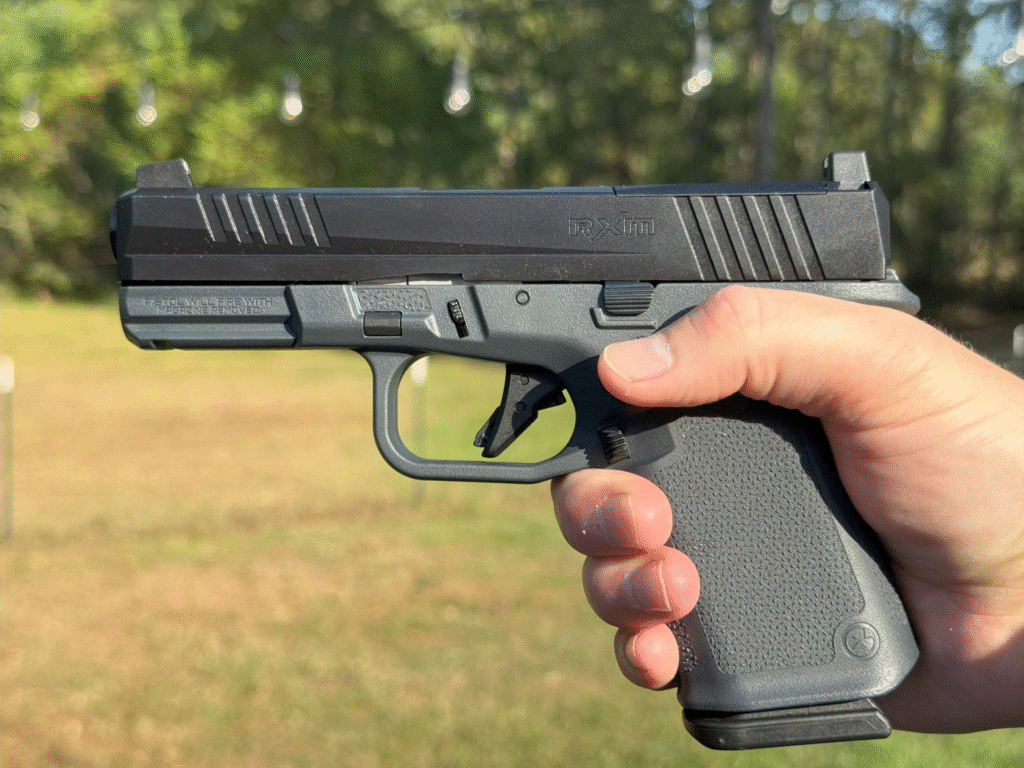 Shooter holding Ruger RXM Glock 19 clone 9mm pistol with Magpul EHG grip during range testing.
