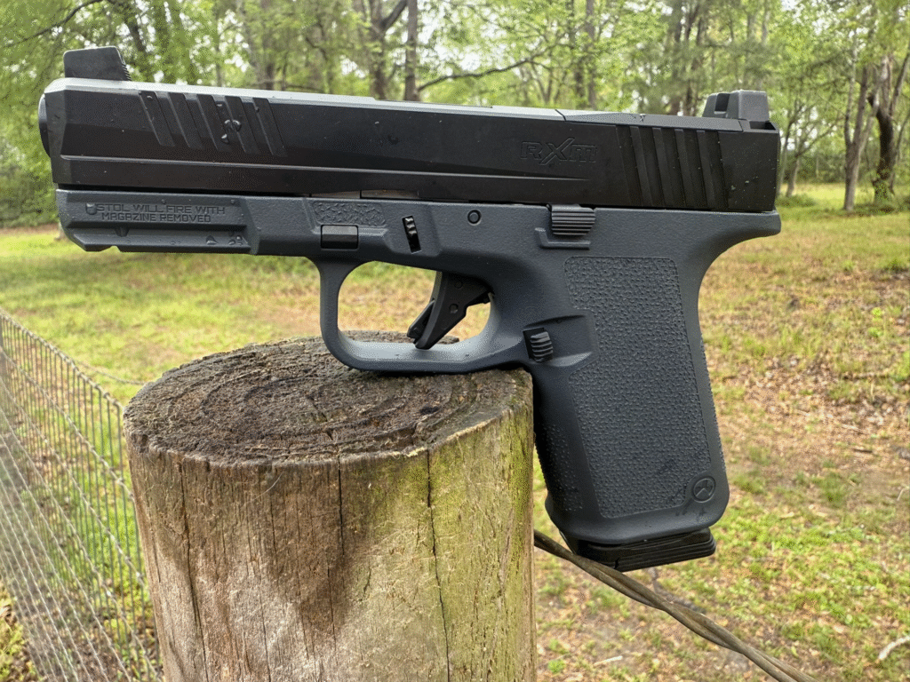Ruger RXM Glock 19 clone compact 9mm pistol resting on a fencepost.