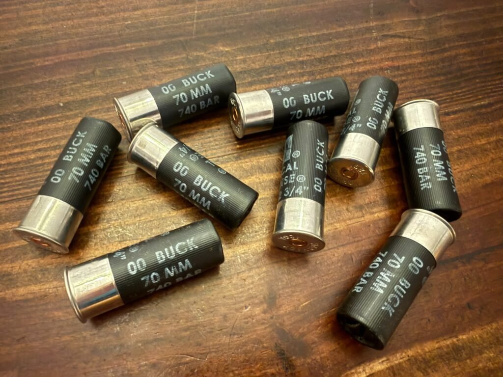 00 buckshot shotgun shells scattered on a wooden surface, showing common defensive shotgun loads used in home defense ammunition for close-range effectiveness and accountability.