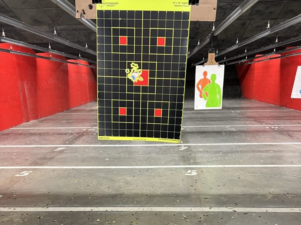 Indoor shooting range target showing a tight shot group on a grid-style paper target, illustrating accuracy testing and practical performance of home defense ammunition during range practice.