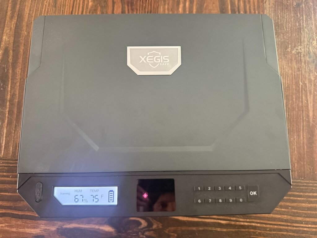 XEGIS palm vein biometric handgun safe closed with keypad, biometric scanner, and digital humidity and temperature display visible on front panel.