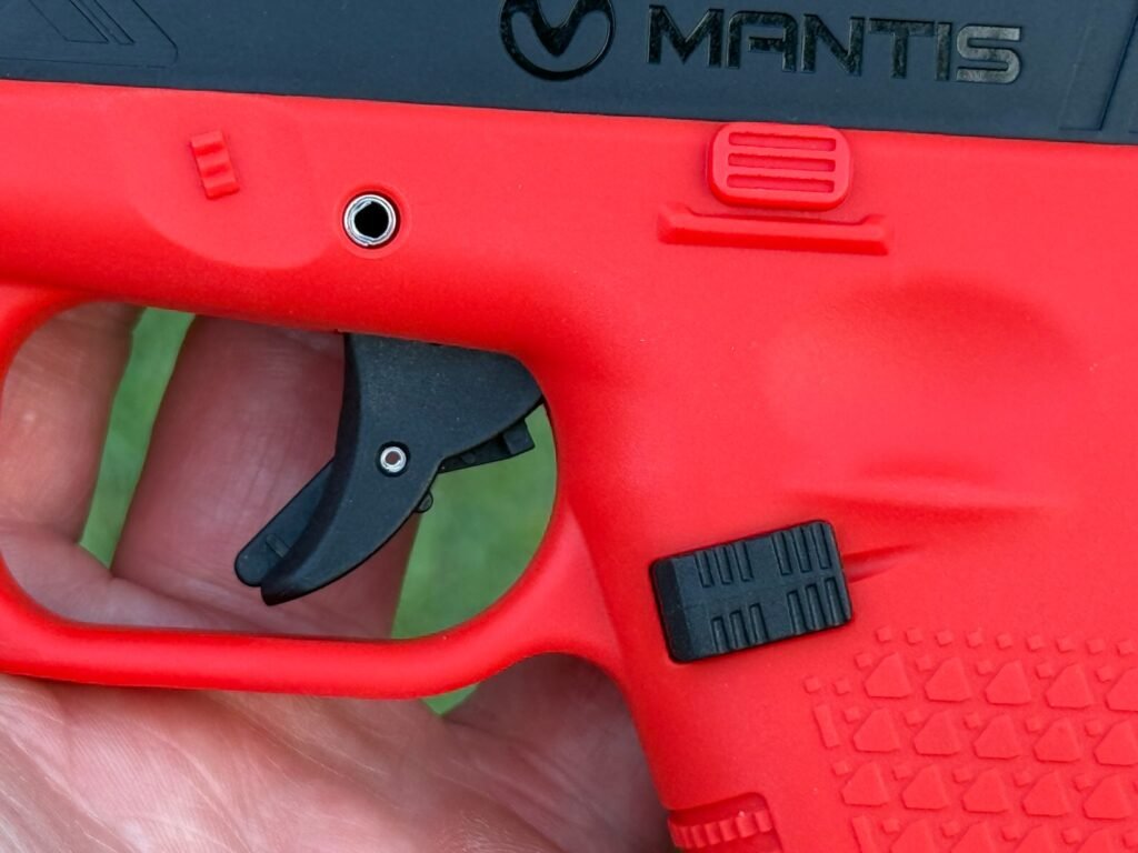 Close-up of Mantis TitanX laser training pistol trigger and controls showing frame detail for dry fire training