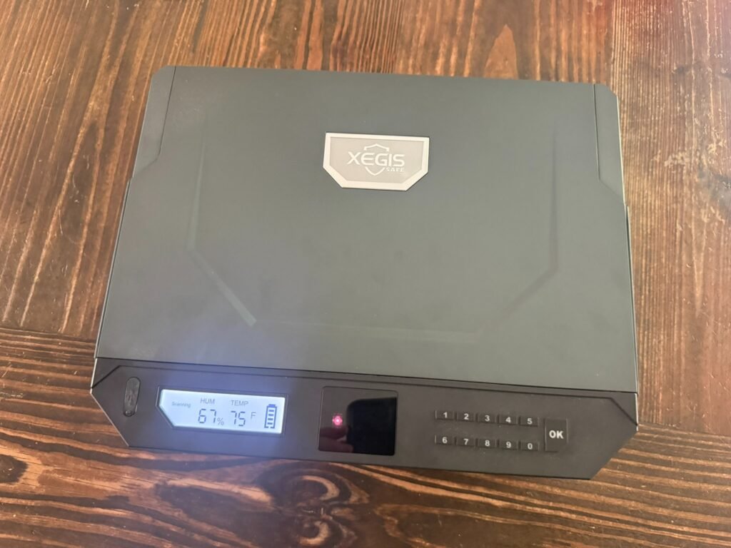 XEGIS biometric gun safe closed with palm vein scanner, keypad entry, and digital humidity and temperature display for quick-access handgun storage.