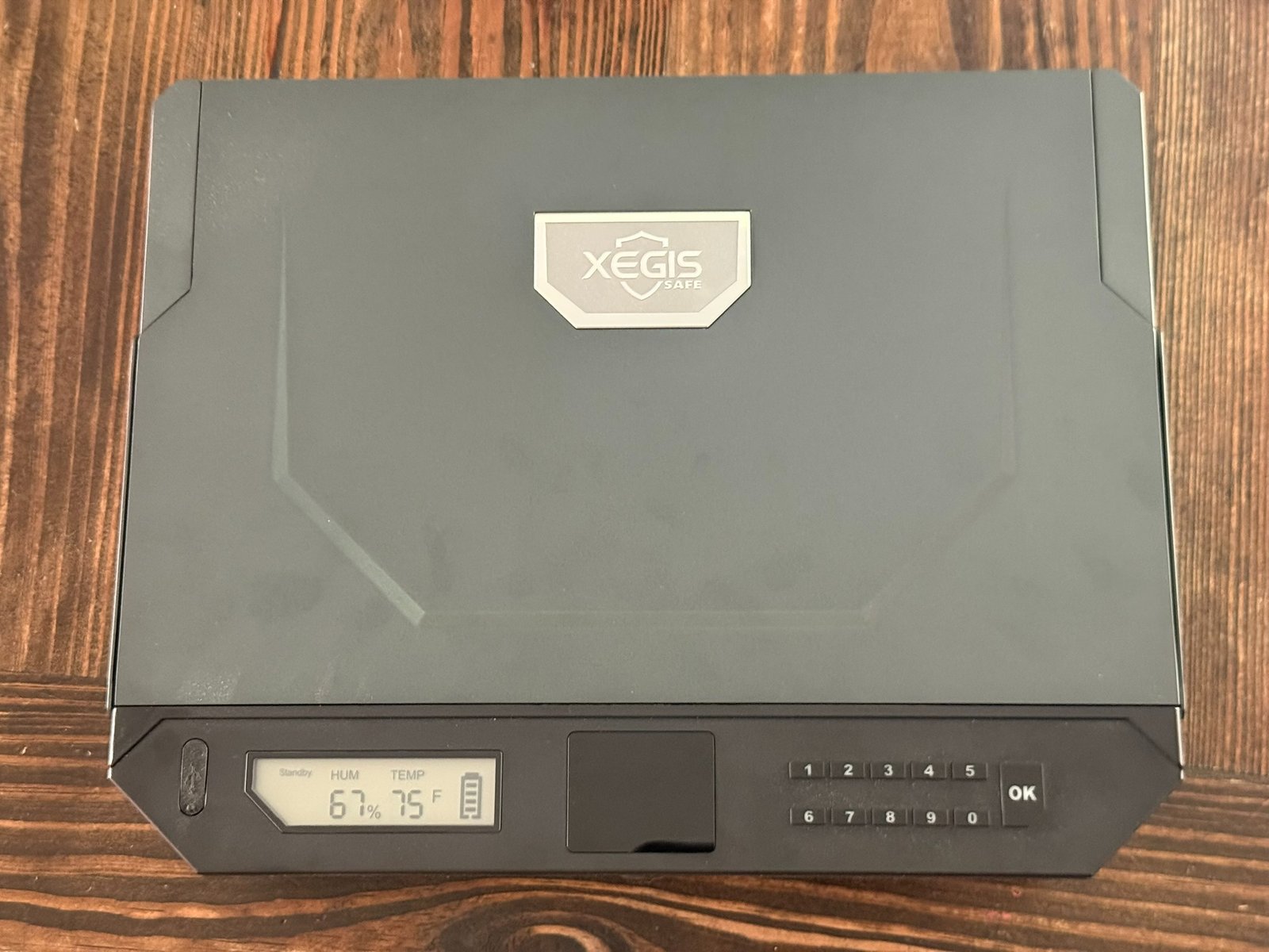 XEGIS biometric gun safe closed showing palm vein scanner, keypad entry system, and digital humidity and temperature display for quick-access handgun storage.