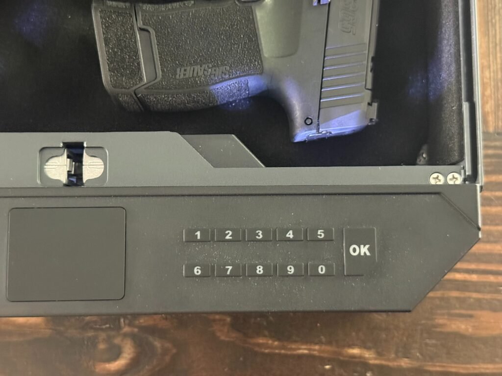 Close-up of XEGIS palm vein biometric handgun safe showing keypad entry system, scanner panel, and interior handgun storage.