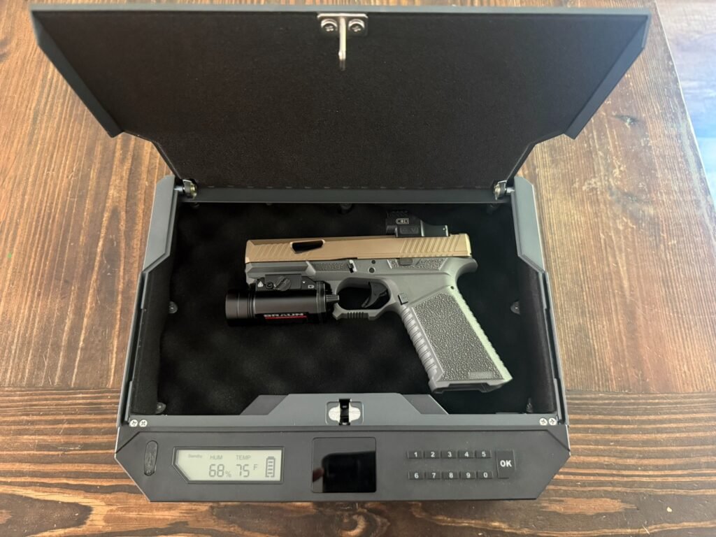 XEGIS biometric gun safe open showing full-size handgun with red dot optic and weapon light, demonstrating capacity for defensive pistol setup.