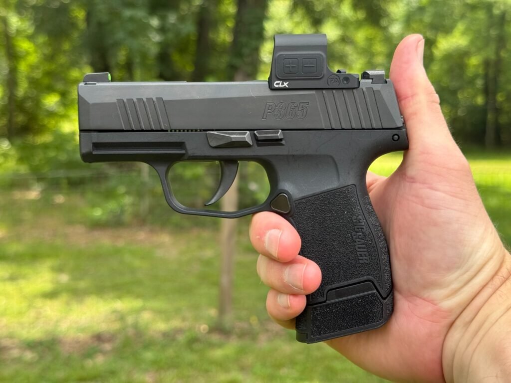 SIG P365 pistol with a Primary Arms CLx Enclosed Reflex Sight mounted, shown in profile while being held outdoors during testing.